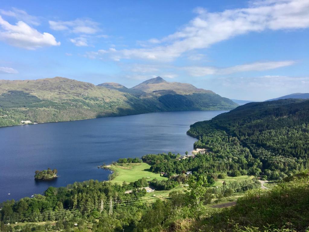 InversnaidLoch Lomond Holiday Park的享有湖泊的空中美景,背景为山脉