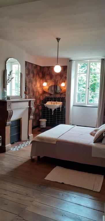 ChervalMaison blanche的一间卧室设有一张大床和一个壁炉