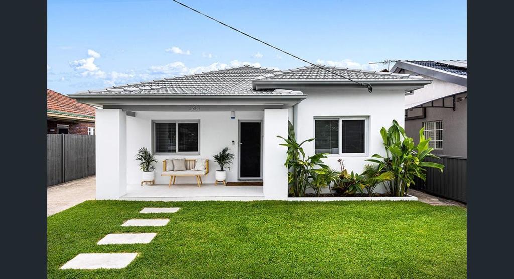 悉尼The South bay's home-Big RoomA的院子里的白色房子,带椅子
