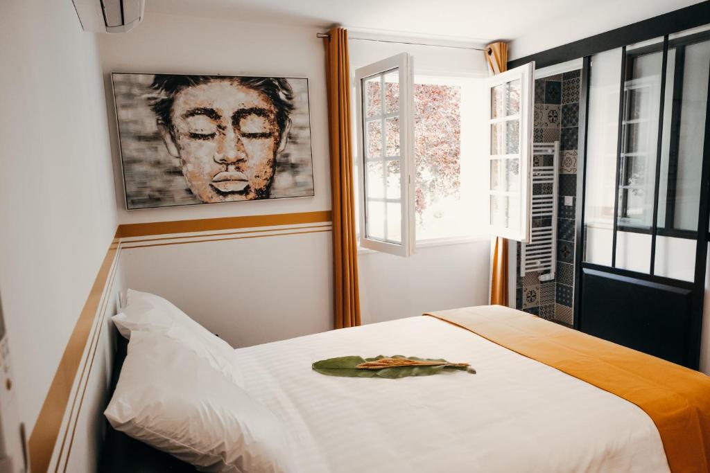 拉特斯特德布赫LA MAISON CACHEE-BA的卧室配有一张白色床,墙上挂着一幅画
