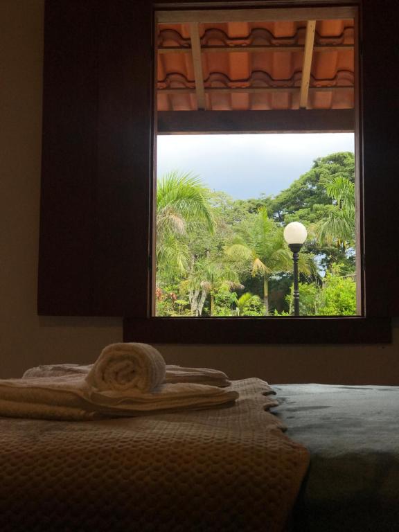 普拉杜斯Chalés Jatobá的美景床上的窗户,带毛巾