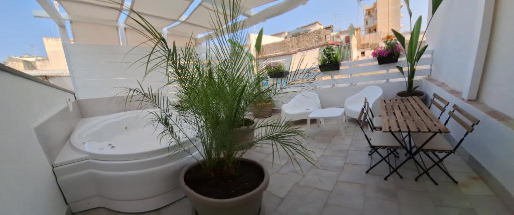 锡拉库扎Luxury home 2的阳台配有桌椅和植物