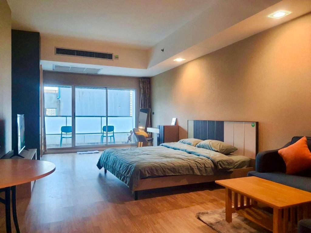 曼谷Baan Nonzee Condo的一间卧室设有一张床和一间客厅。