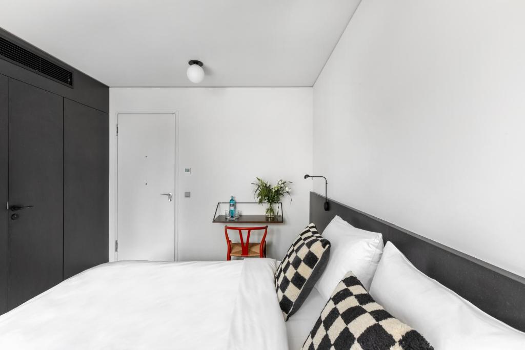 柏林numa I Savi Rooms & Apartments的一间卧室配有一张带黑白枕头的床