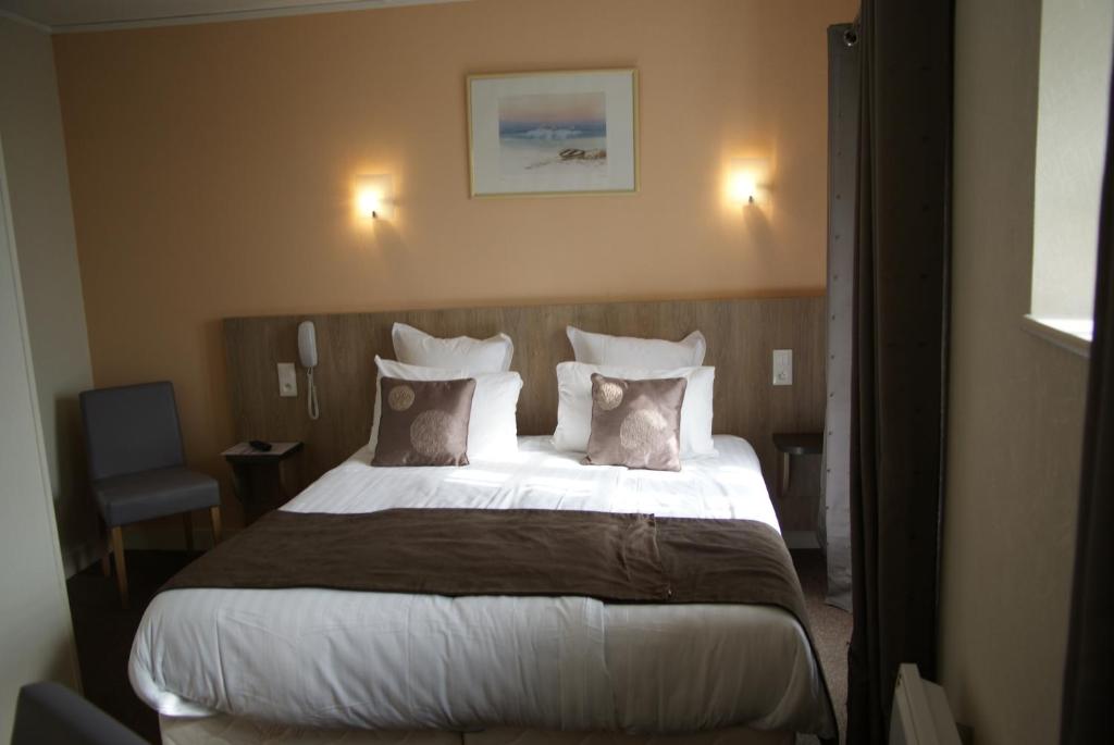 圣米歇尔山老旅馆的一间卧室配有一张带枕头的大床