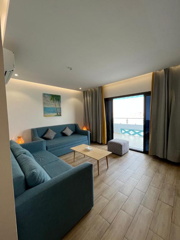 杜拉特阿拉尔غرفة صالة بلكونة على الشاطئ - عوائل的客厅配有蓝色的沙发和桌子