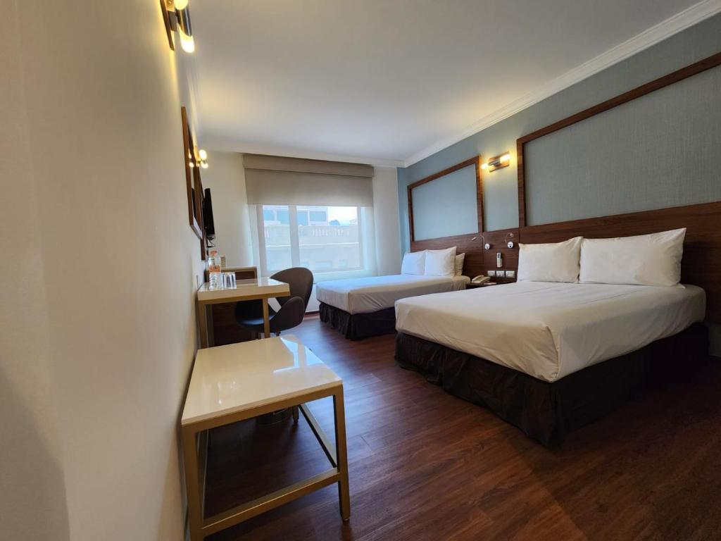 墨西哥城Hotel Ritz Ciudad de México的酒店客房配有两张床和一张书桌