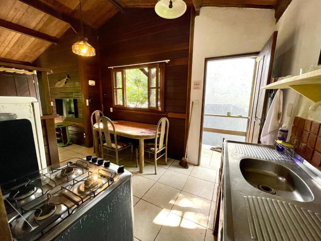 阿布拉奥Casa Selva - Vila do Abraão - Ilha grande的厨房配有炉灶、水槽和桌子