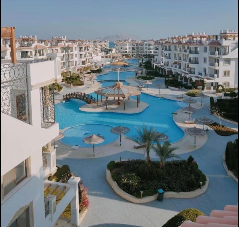 沙姆沙伊赫Sharm Hills Aqua park Resort的享有带游泳池和遮阳伞的度假村的空中景致