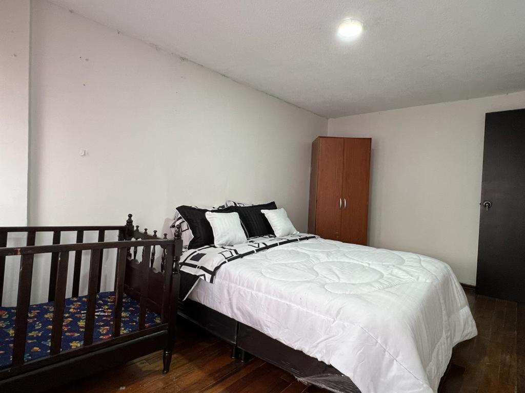 波哥大La Candelaria的卧室配有黑白床和橱柜。
