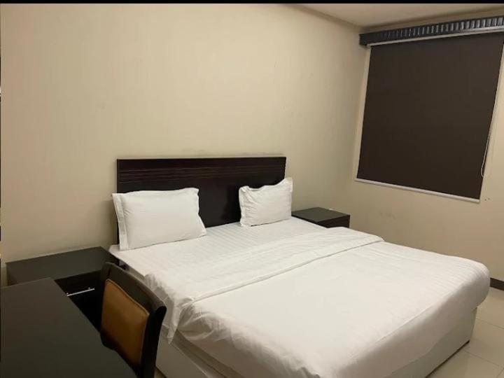 利雅德Quiet Rooms 8的一间卧室配有一张带白色床单的大床