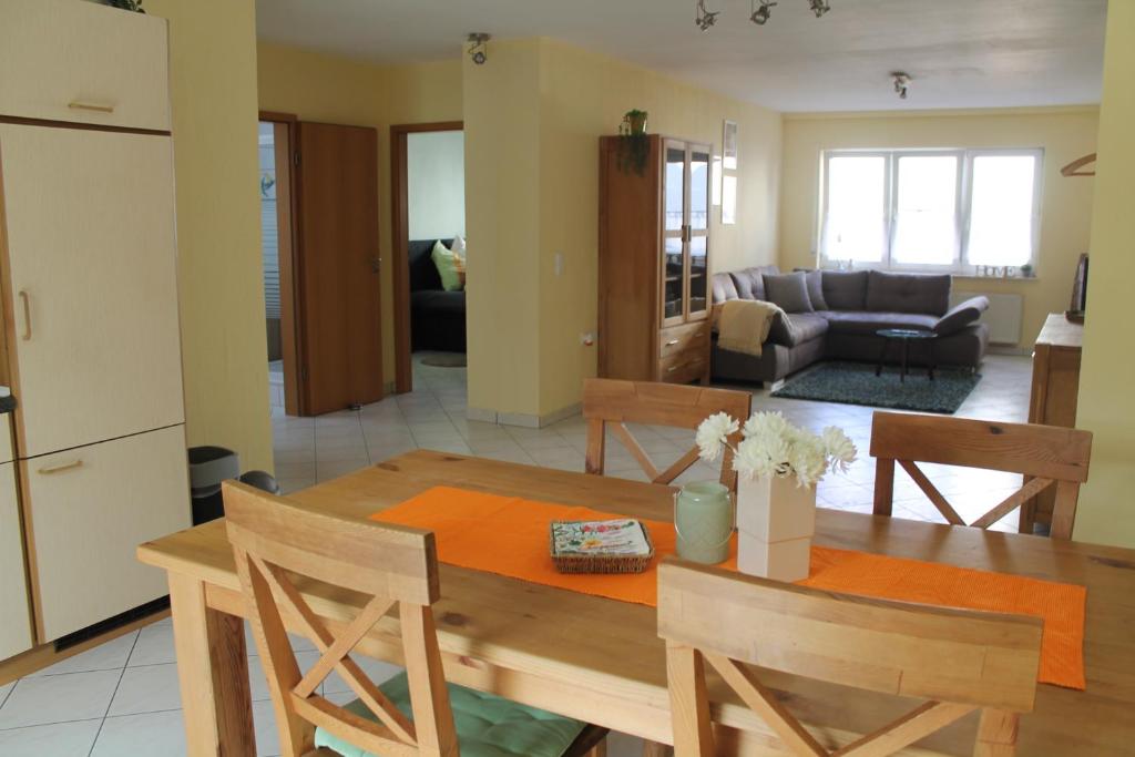 韦茨拉尔Gemütliches Apartment, nahe Wetzlar的厨房以及带木桌和椅子的客厅。