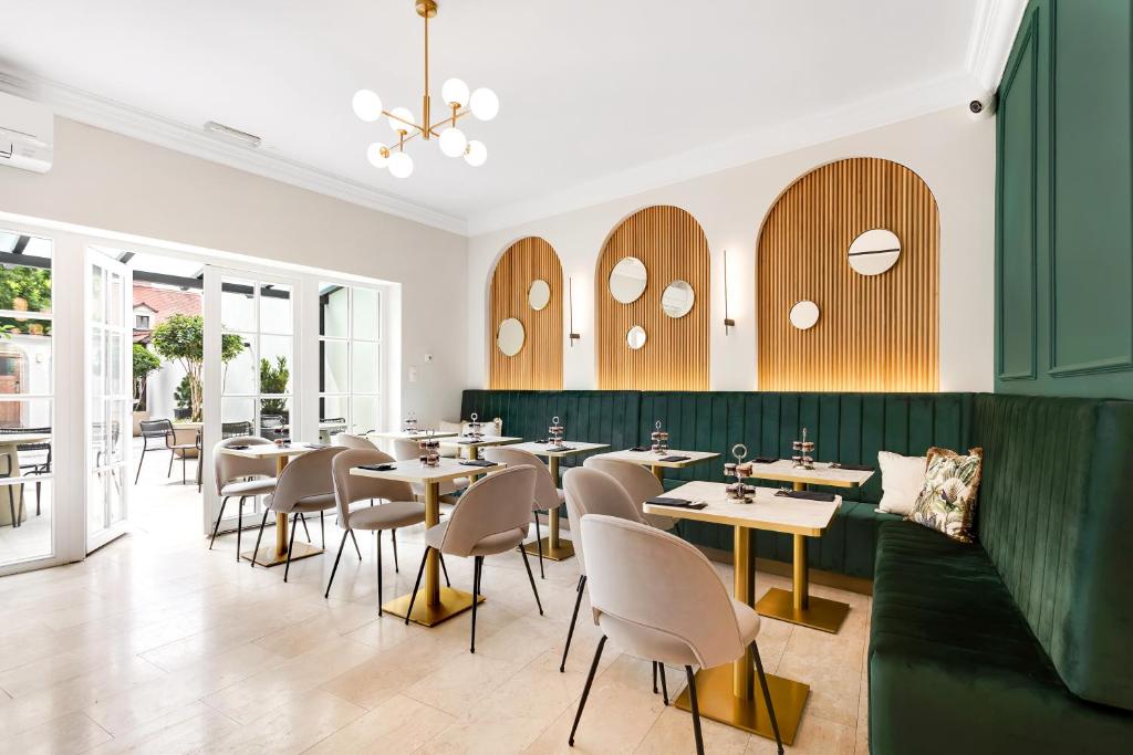 卢布尔雅那Bloom Hotel的一间带桌椅和绿色墙壁的餐厅