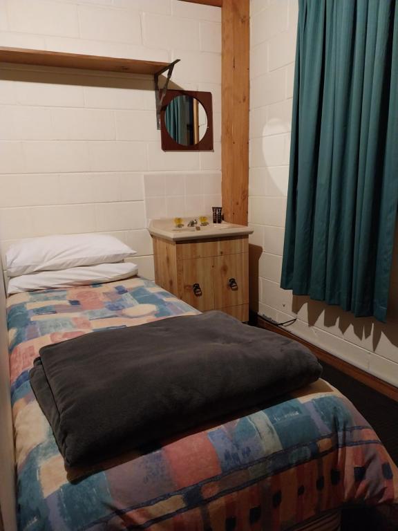 金德拜恩金达拜尼木屋旅馆的客房设有两张床、一个水槽和镜子
