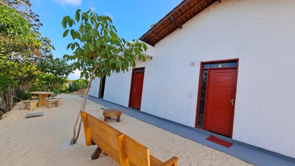 巴雷里尼亚斯Hostel Flor de Ipê的红色门楼前的长凳