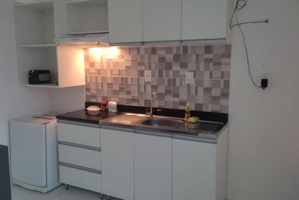 Villa ElisaDepartamento en Villa Elisa.的厨房配有白色橱柜和水槽