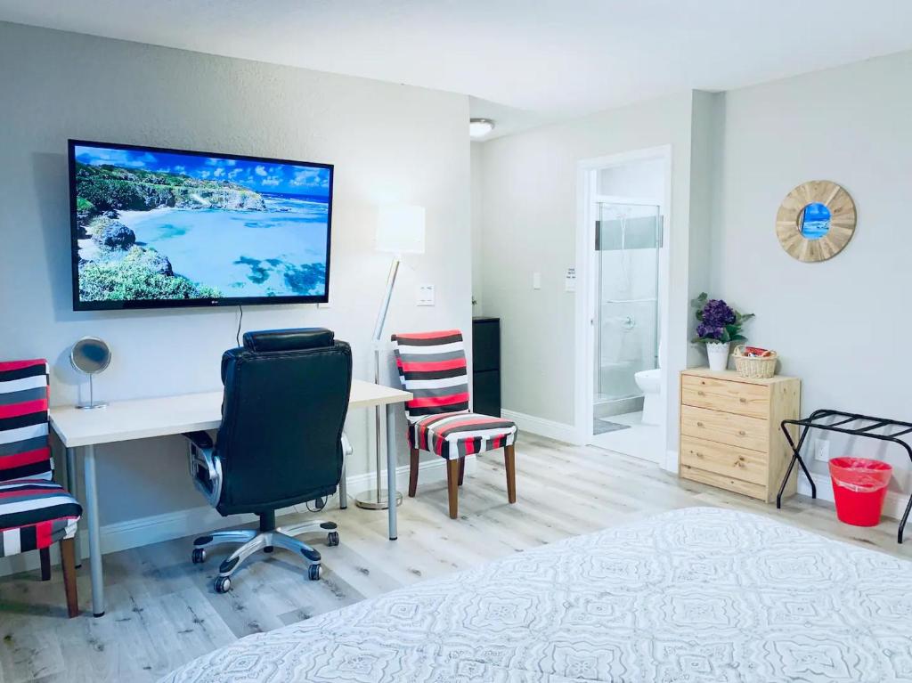 East Palo AltoBrand new suite, 1mi to Meta, 3mi to Stanford的客房设有桌椅和墙上的电视。