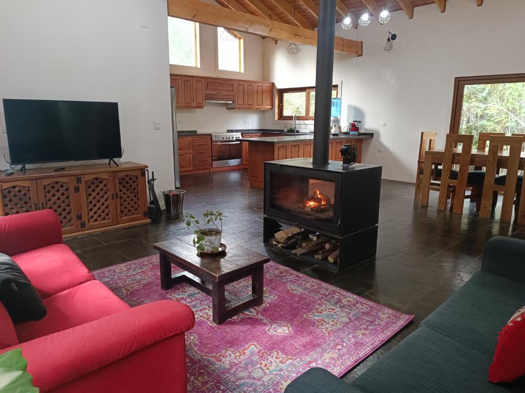 RecintoCasa con quincho y piscina privados的客厅设有红色的沙发和壁炉