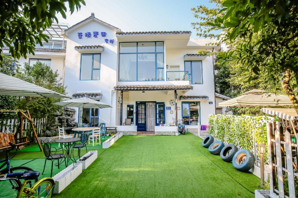 杭州杭州蓝屿麦田客栈的前面有绿色草坪的房子