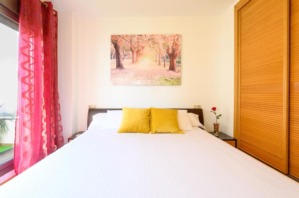 马拉加Apartamento Litoral Blue的一间卧室配有一张带黄色枕头的大床