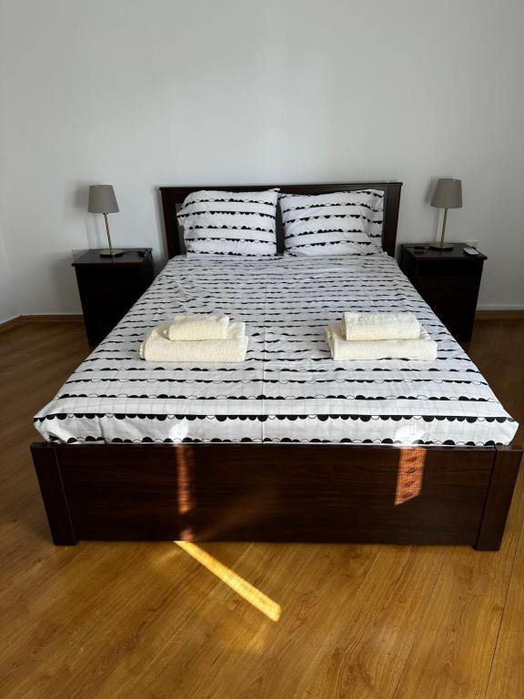 波利斯Spitaki的一张带两个枕头的床和两张桌子