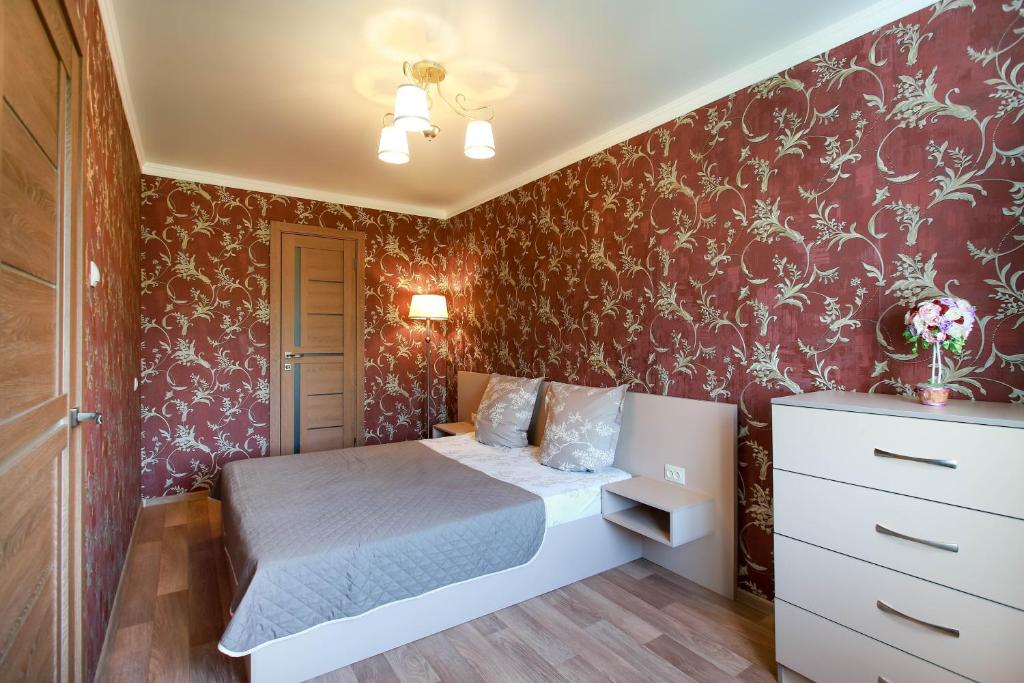 尼古拉耶夫Двушка люкс автовокзал的一间小卧室,配有床铺和红色壁纸