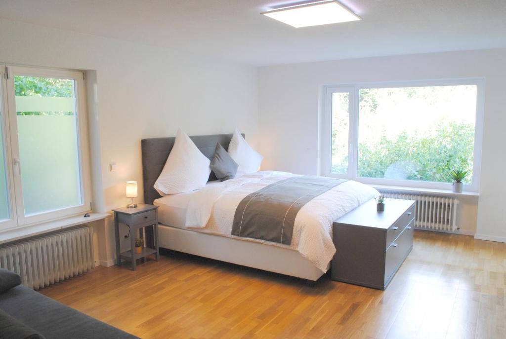 巴登韦勒FeWo-Hochblauen的一间白色卧室,配有床和2个窗户