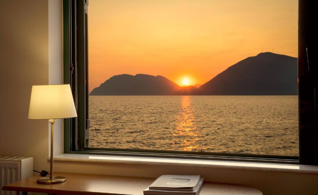 帕特雷Rio Beach Residence的享有大海和日落美景的窗户