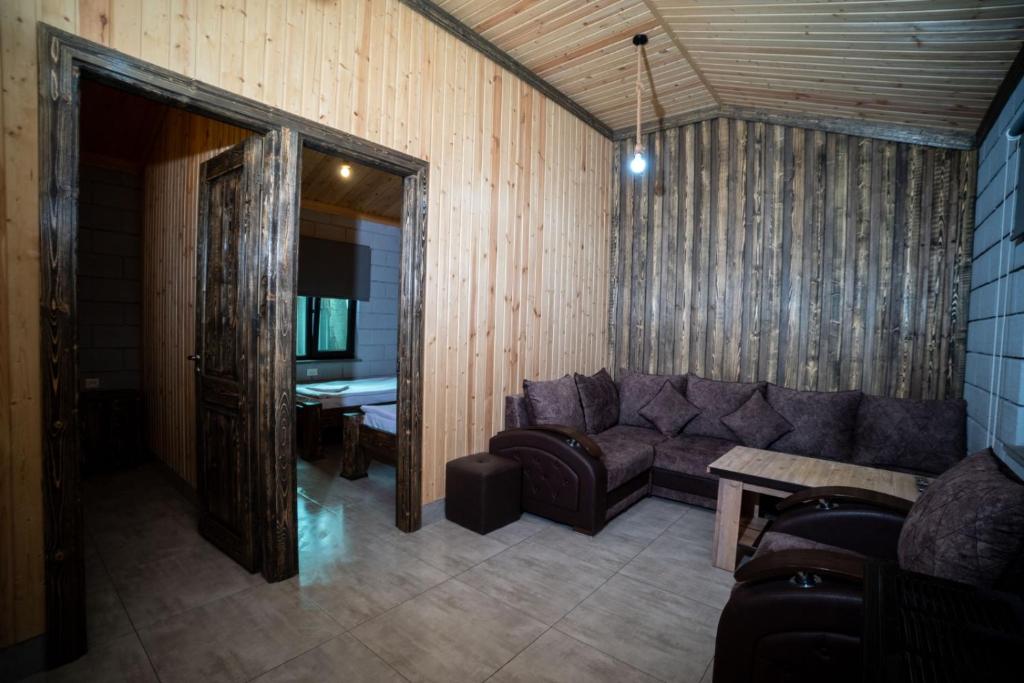 塞凡Arevik Resort Cottages的客厅配有沙发和桌子