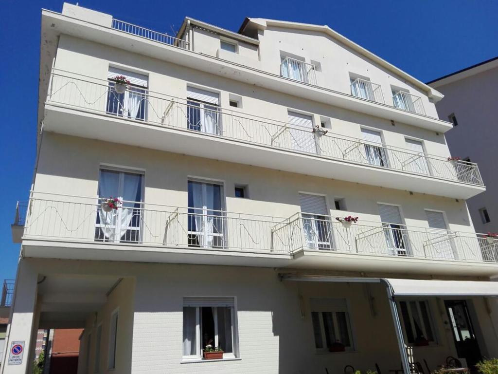 里米尼Hotel Villa Mon Reve的一座带阳台的白色建筑,鲜花盛开