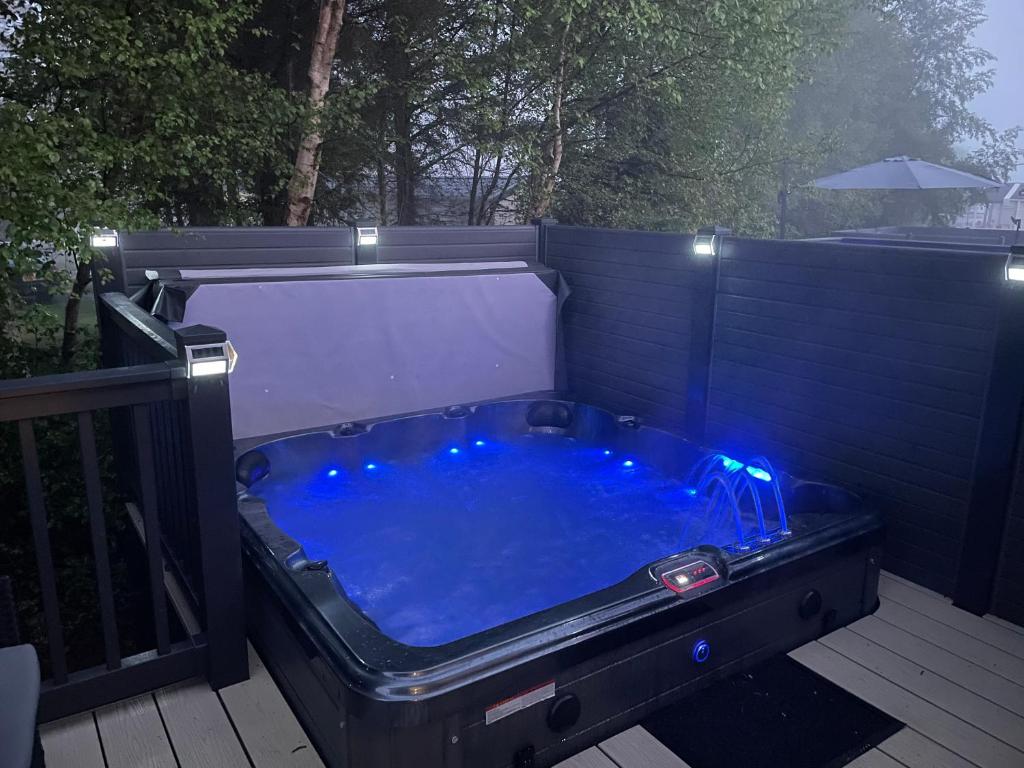 SwarlandSummer’s Lodge的甲板上配有蓝色灯光的热水浴池