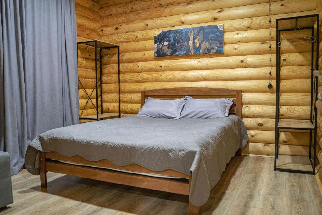 博尔若米Eco House Borjomi的卧室配有木墙内的一张床