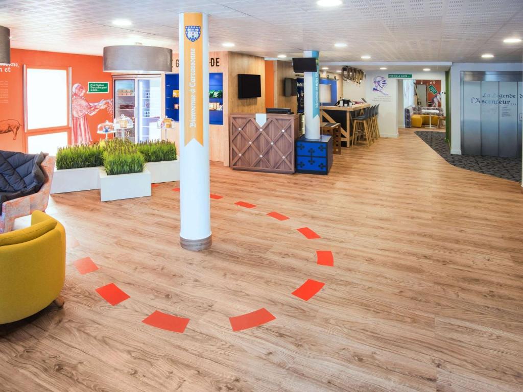 卡尔卡松卡尔卡松城市宜必思尚品酒店的客房铺有木地板,配有红色的方形