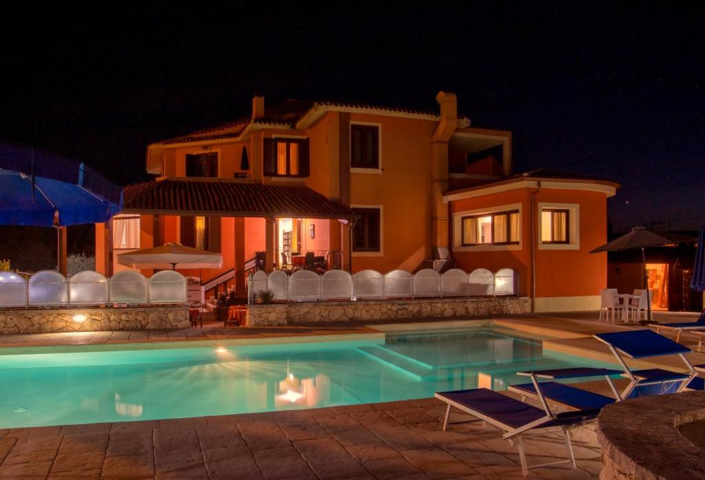 Uri考拉鲁坎达撒森图酒店的夜间在房子前面的游泳池