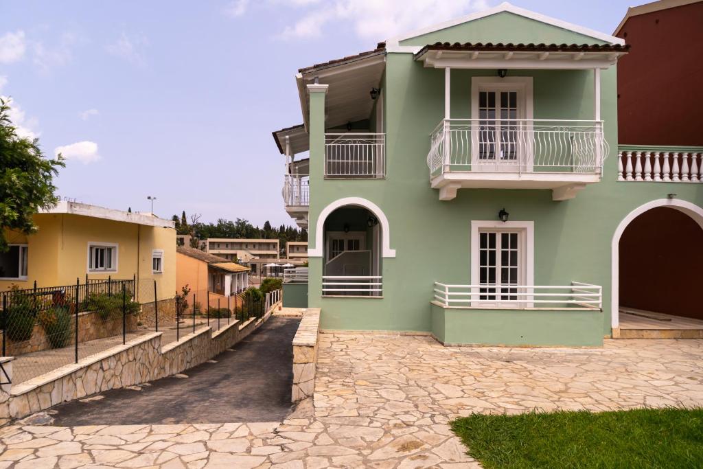 达西亚Spiros Athinaios Apartment's的带阳台和车道的绿色房屋