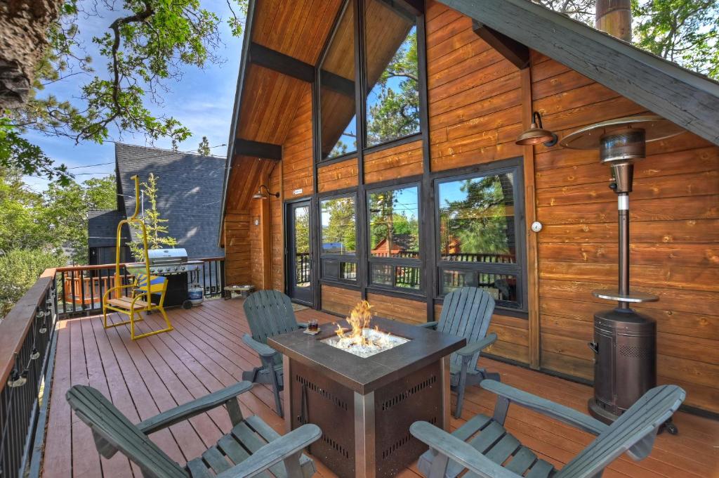 大熊湖New!!! Dreamy Bear Haus- Updated Retro Retreat & Spa, Pet & Kid Friendly的小屋设有1个带壁炉和椅子的甲板