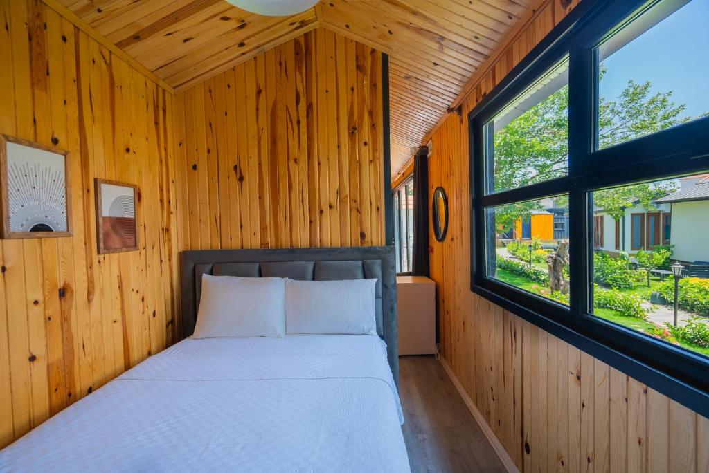 博德鲁姆İNCİ BOUTİQUE APART的木间内的一张床位,设有两个窗户