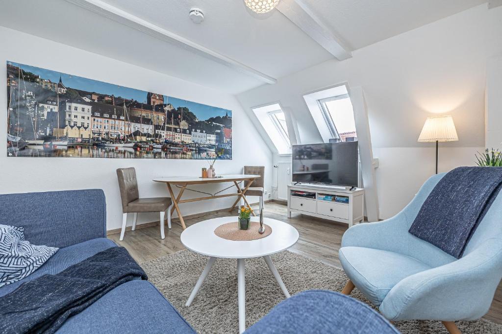 弗伦斯堡fewo1846 - Im Sonnenhof - komfortable 2-Zimmer-Wohnung im Stadtzentrum的客厅配有2把蓝色椅子和桌子