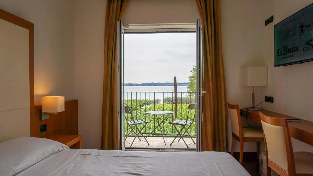西尔米奥奈马维诺酒店的一间卧室设有一张床,享有阳台的景色