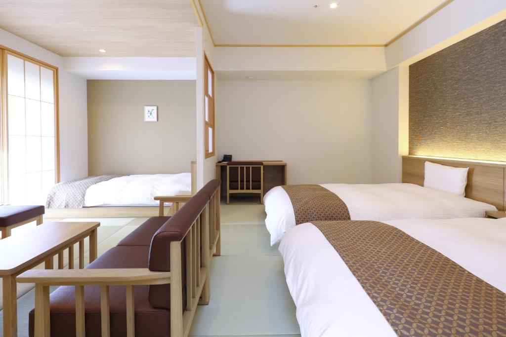 东京Dormy Inn Premium Ginza的酒店客房配有两张床和一张书桌