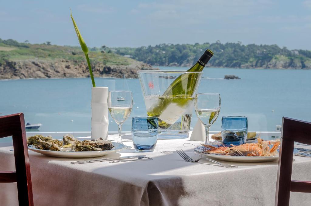 内维兹国际之家港口与落水洞酒店的一张桌子,上面放着一瓶葡萄酒和盘子