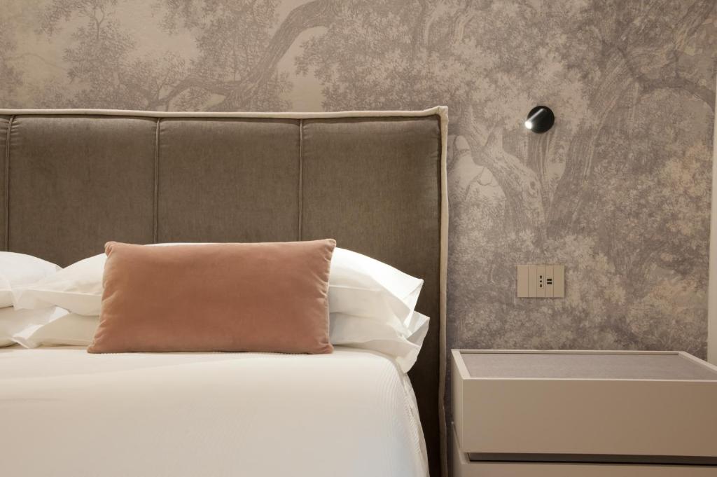 莱维科特尔梅Ambiente 90的一间卧室配有一张带枕头和墙壁的床