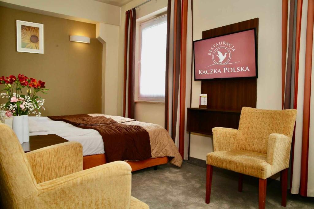 凯尔采泰科佐维梅林酒店的酒店客房带一张床、一张桌子和椅子
