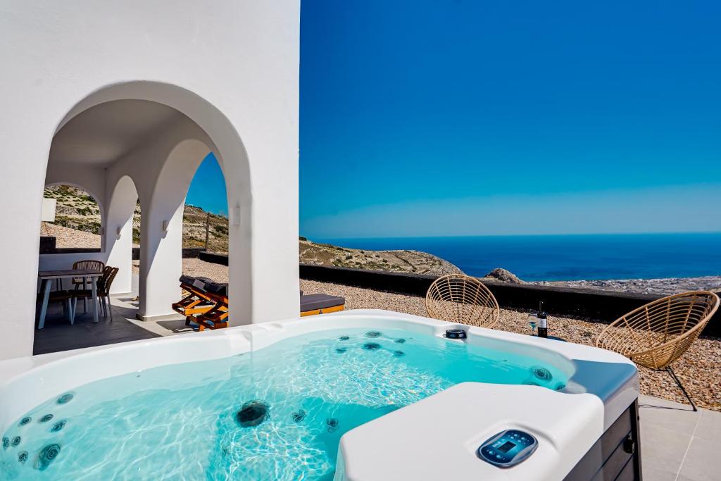 皮尔戈斯Acria Villas的露台的热水浴池,背景为大海
