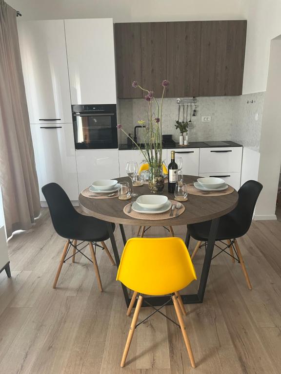 木洛希尼Apartman Sea story Mali Lošinj的厨房里配有带黄椅的餐桌
