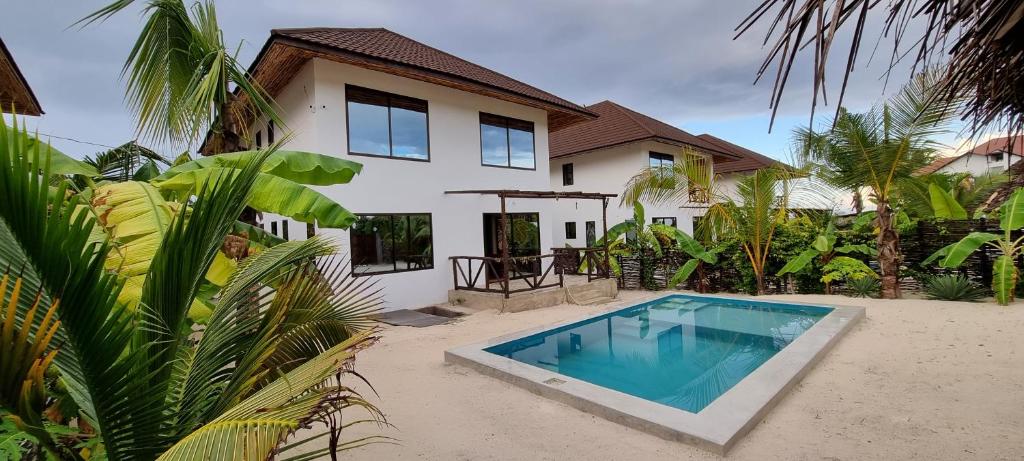 布韦朱Maracuja villa Zanzibar的别墅前设有游泳池