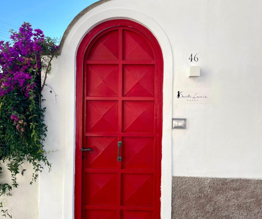 卡普里SUITE LUCIA的白色建筑一侧的红色门
