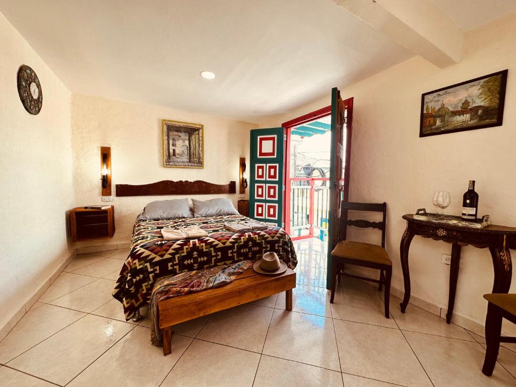 萨兰托IntiLuna Hostel的卧室配有1张床、1张桌子和1把椅子