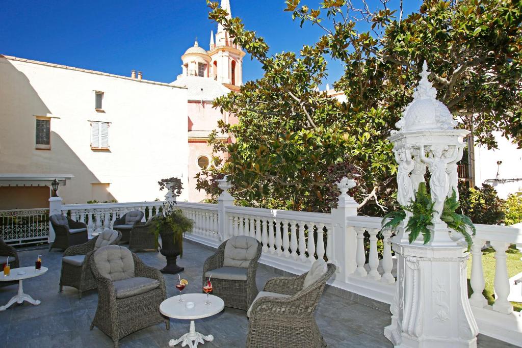 卡尔维木兰花酒店的一个带桌椅的庭院和白色的围栏
