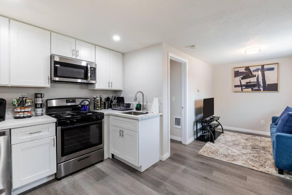 圣地亚哥San Diego's Cozy Gem的厨房配有白色橱柜和炉灶烤箱。